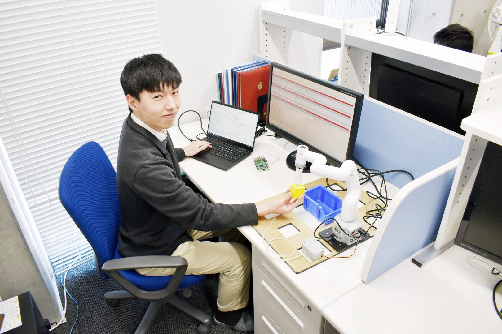 ロボットアームの評価実験をする竹本修先生